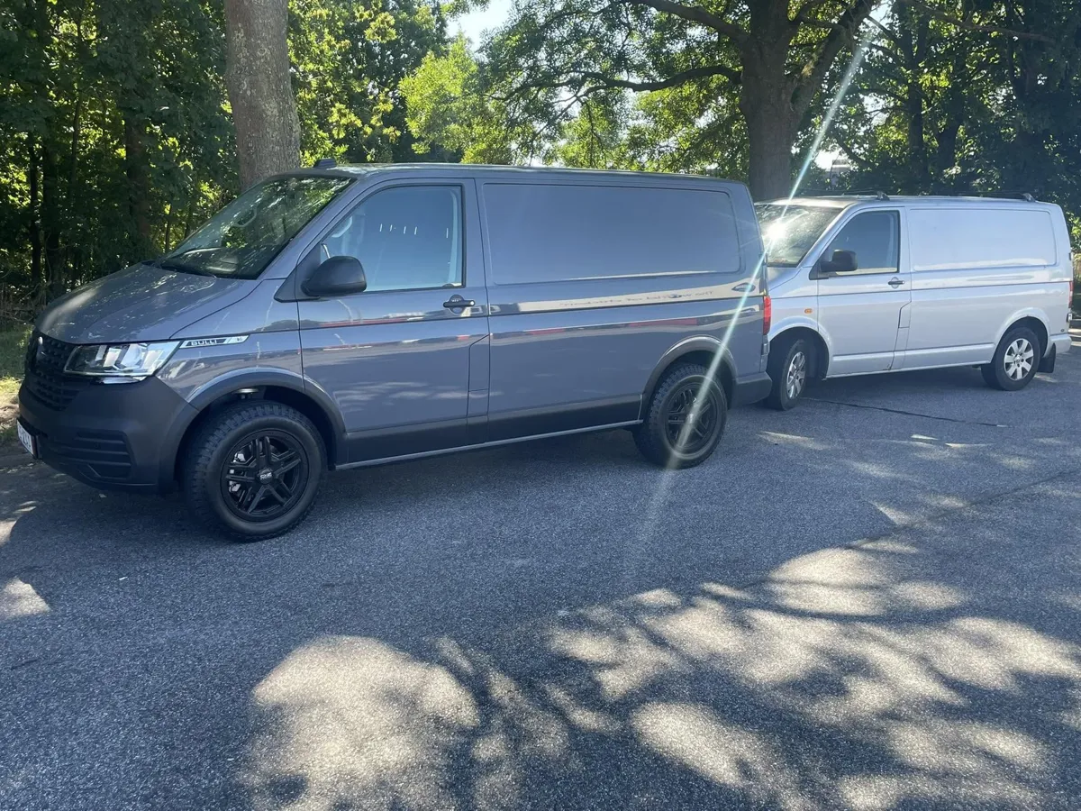 Två skåpbilar parkerade under lövträd
